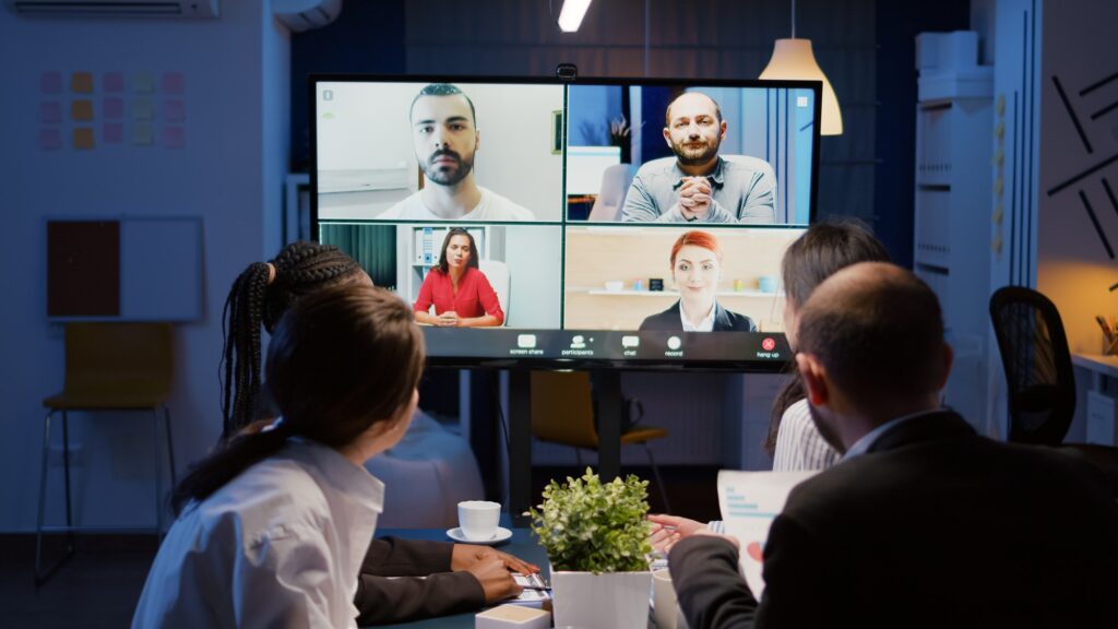 Multi ethnic businesspeople discussing company statistics with remote coworkers